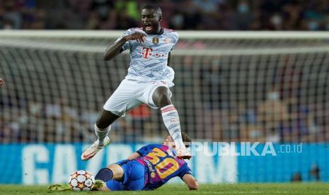 Pemain Bayern Muenchen Dayot Upamecano (atas) berebut bola dengan pemain FC Barcelona Pablo Martin 