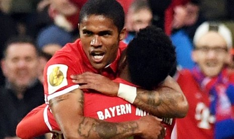 Pemain Bayern Muenchen Douglas Costa (kiri) dipeluk oleh David Alaba setelah menjebol gawang Wolfsbrug dalam laga Piala Jerman.