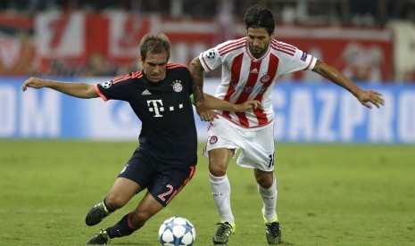 Pemain Bayern Muenchen, Phillip Lahm (kiri) dan pemain Olympiakos Alejandro Domininguez (kanan) berebut bola dalam lanjutan pertandingan Liga Champions