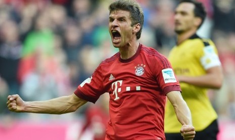 Pemain Bayern Muenchen Thomas Mueller melakukan selebrasi usai mencetak gol ke gawang Borussia Dortmund saat tampil di Allianz Arena, Senin (5/10) dini hari WIB