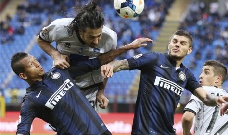 Pemain belakang Atalanta Mario Yepes berebut bola dengan pemain Inter Milan Fredy Guarin dan Mauro Icardi dalam pertandingan Liga Serie A, Ahad (23/14).