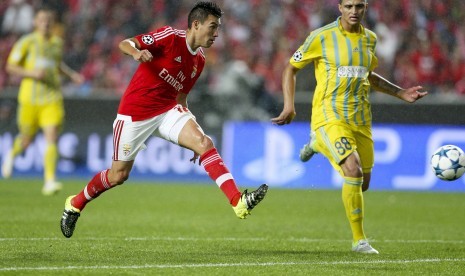 Pemain Benfica Nico Gaitan melepaskan tendangan di depan pemain Astana Roger Canas pada laga grup C Liga Champions antara Benfica dan Astana di Luz Stadium, Lisabon. 