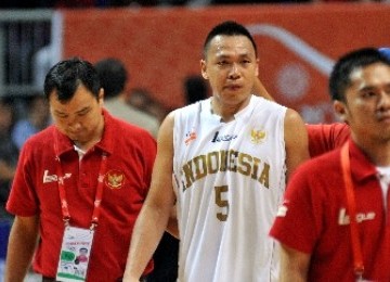 Pemain bola basket Indonesia, Andi Poedjakesuma (tengah), ditenangkan offisial usai melawan tim Thailand pada babak semifinal SEA Games ke-26 di Britama Arena Sport Mall, Jakarta, Jumat (18/11) malam.