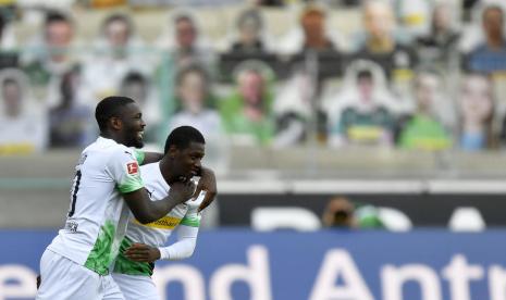 Pemain Borussia Moenchengladbach Mamadou Doucoure (kanan) dan Marcus Thuram merayakan gol ke gawang Union Berlin dalam pertandingan Bundesliga Jerman, Ahad (31/5).