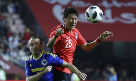 Pemain Bosnia, Edin Visca (kanan) berebut bola dengan pesepak bola Korea Selatan, Jung Woo-young, pada laga persahabatan di Seoul, Jumat (1/6). Visca mencetak tiga gol pada laga ini.