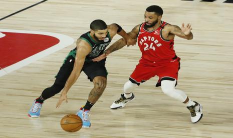 Pemain Boston Celtic Jayson Tatum (kiri) membawa bola dihalangi pemain Toronto Raptors Norman Powell dalam pertandingan play-off NBA, Selasa (8/9) WIB.