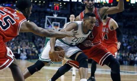 Pemain Boston Celtics, Evan Turner (tengah), mencoba melewati adangan pemain Chicago Bulls dalam pertandingan basket NBA di Boston pada Rabu (9/12). 