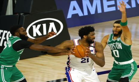 Forward Boston Celtics Jayson Tatum (kanan) menjaga center Philadelphia 76ers Joel Embiid dalam pertandingan kedua play-off WIlayah Timur NBA, Kamis (20/8) WIB di Lake Buena Vista, Florida. 