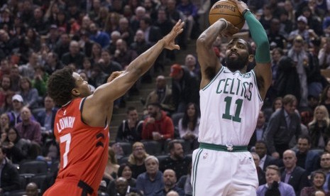 Pemain Boston Celtics, Kyrie Irving (kanan), melepaskan tembakan di tengah hadangan pemain Toronto Raptors, Kyle Lowry, dalam pertandingan basket NBA di Toronto pada Selasa (6/2). 