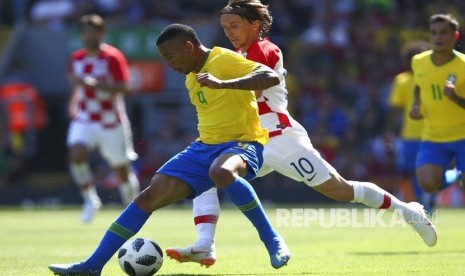 Pemain Brasil Gabriel Jesus berebut bola dengan pemain Kroasia Luka Modric pada laga persahabatan antara Brasil dan Kroasia di Stadion Anfield di Liverpool, Inggris, Ahad (3/6).