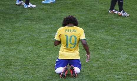 Pemain Brasil, Willian, tertunduk lesu setelah mereka menelan kekalahan telak 1-7 dari Jerman di semifinal Piala Dunia 2014 di Stadion Mineirao, Belo Horizonte, Selasa (8/7). 