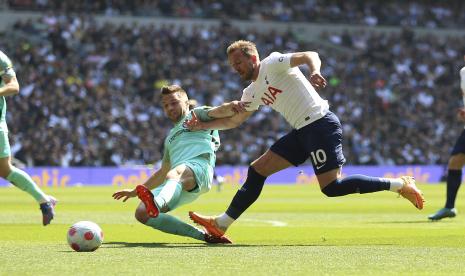 Pemain Brighton and Hove Albion Joel Veltman (kiri) dan pemain Tottenham Hotspur Harry Kane berebut bola dalam pertandingan sepak bola Liga Inggris di Stadion Tottenham Hotspur, London, Sabtu (16/4/2022).