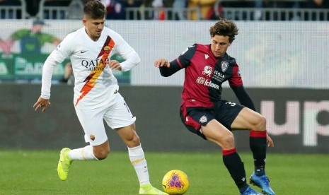 Pemain Cagliari Luca Pellegrini (kanan) berebut bola dengan gelandang AS Roma pada pertandingan Liga Italia Serie A di Sardegna Arena, Cagliari, Sardinia, Senin (2/3) dini hari WIB. Roma mengalahkan Cagliari 3-2. 