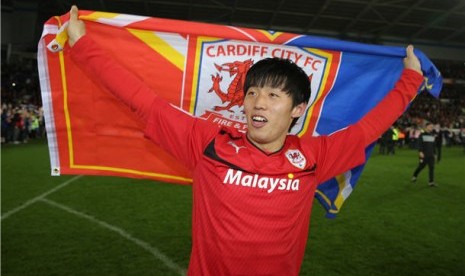 Pemain Cardiff City asal Korea, Kim Bo-Kyung, melakukan selebrasi usai meraih tiket promosi ke Liga Primer Inggris setelah menghadapi Charlton di Cardiff City Stadium, Wales, Selasa (16/4). 