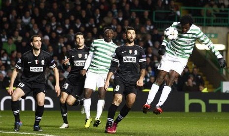 Pemain Celtic, Efe Ambrose (kanan), melepaskan sundulan yang berhasil dijinakan kiper Juventus, Gianluigi Buffon (tak terlihat), di leg pertama babak 16 besar Liga Champions di Celtic Park, Glasgow, Selasa (12/2).  