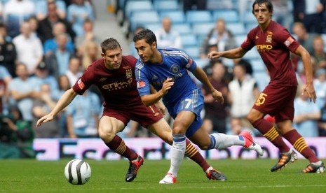 Pemain Chelsea, Eden Hazard (tengah) berupaya melepaskan diri dari hadangan pemain Manchester City dalam laga Community Shield, Ahad (12/8) 2012. 