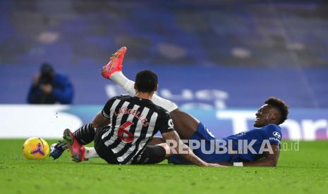 Pemain Chelsea Tammy Abraham (kanan) memegang kakinya setelah dijegal oleh pemain Newcastle United Jamaal Lascelles pada pertandingan sepak bola Liga Utama Inggris antara Chelsea dan Newcastle United di Stadion Stamford Bridge di London, Inggris, Selasa (16/2) dini hari WIB.