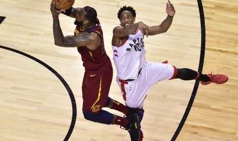  Pemain Cleveland Cavaliers LeBron James (23) mencoba melakukan tembakan dengan penjagaan dari guard Toronto Raptors, DeMar DeRozan (10) pada gim pertama semifinal wilayah timur di Toronto, Selasa (1/5) waktu setempat