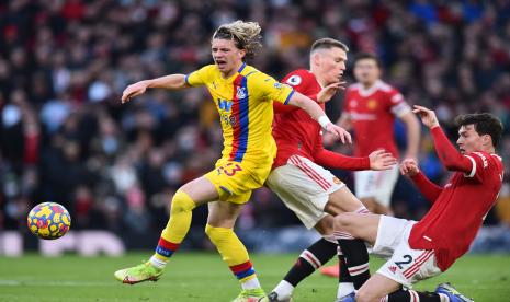 Pemain Crystal Palace Conor Gallagher (kiri) berduel dengan penggawa MU McTominay (tengah) dan Victor Lindelof (kanan) pada laga di Old Trafford, Ahad (5/12).