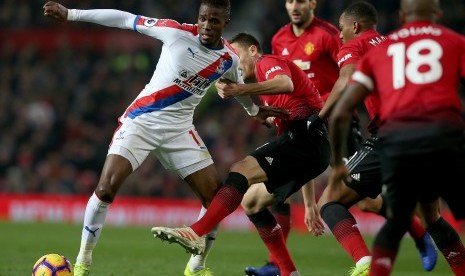 Pemain Crystal Palace Wifried Zaha (kiri) diadang oleh pemain Manchester United Nemanja Matic (tengah). 