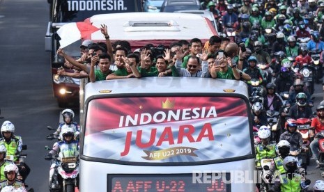 Pemain dan ofisial Timnas U-22 Indonesia menaiki bus tingkat ketika mengikuti konvoi menuju Istana Negara saat melintas di Jalan Sudirman, Jakarta, Kamis (28/2/2019). 