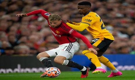 Pemain debutan Manchester United (MU) Mason Mount (kiri) berduel dengan penggawa Wolverhampton Wanderes Nelson Semedo pada pertandingan Liga Primer Inggris 2023/2024 di Old Trafford, Selasa (15/8/2023). 