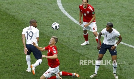 Pemain Denmark Andreas Cornelius berebut bola dengan pemain Prancis Djibril Sidibe pada pertandingan grup C Piala Dunia 2018 antara Denmark dan Prancis di Stadion Luzhniki di Moskow, Rusia, Selasa (26/6).