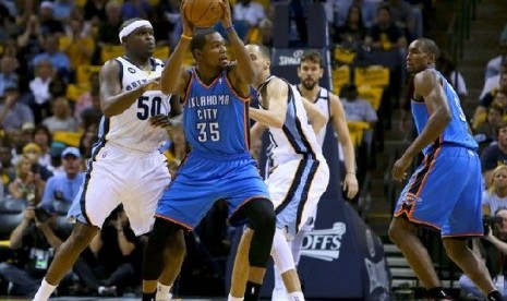 Pemain depan Grizzlies Kevin Durant sedang membawa bola dan dihadang sejumlah pemain Thunder 