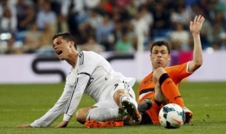 Pemain depan Real Madrid Cristiano Ronaldo (kiri) saat dijegal pemain Valencia Javier Fuego dalam lanjutan Laliga Spanyol di Stadion Santiago Bernabeu, Senin (5/5) dini hari.