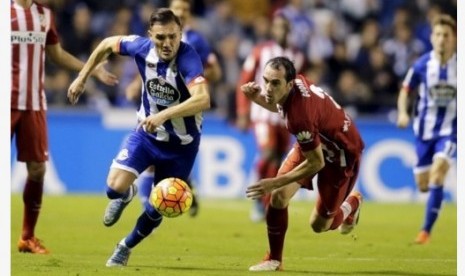 Gelandang Deportivo La Coruna Lucas Perez (kiri) berebut bola dengan bek tengah Atletico Madrid Diego Godin.