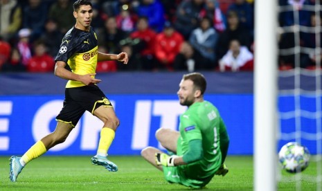 Pemain Dortmund Achrf Hakimi, kiri, mencetak gol ke gawang Slavia yang dijaga Ondrej Kolar di penyisihan grup F Liga Champions, di Praha, Ceko, Kamis (3/10).