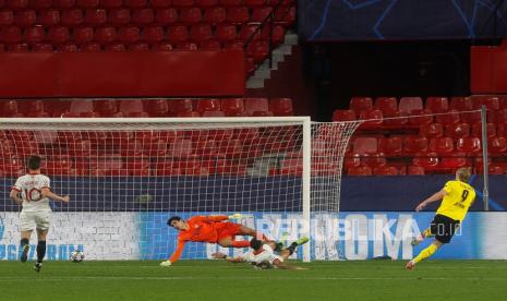 Penyerang Dortmund Erling Haaland (kanan) mencetak gol ketiga timnya pada babak 16 besar Liga Champions ke gawang Sevilla di Stadion Ramon Sanchez Pizjuan di Sevilla, Spanyol, Kamis (18/2) dini hari WIB. 