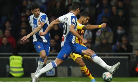 Pemain Espanyol Bernardo Espinosa menjaga striker Barcelona Luis Suarez yang mencoba melepaskan tendangan. Espanyol menahan imbang BArcelona 2-2.