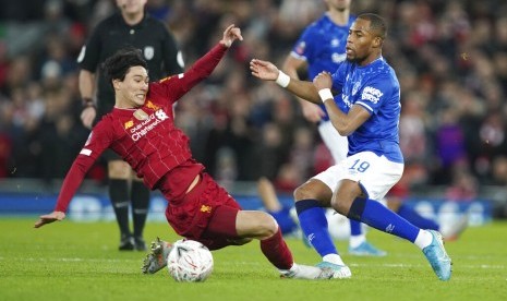 Pemain Everton Djibril Sidibe (kanan) berusaha menghentikan gerakan penyerang Liverpool Takumi Minamino. Wali Kota Liverpool mengizinkan pertandingan kedua tim berlangsung di Goodison Park, markas Everton.