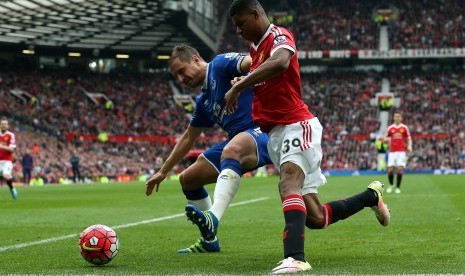 Pemain Everton, Phil Jagielka (kiri), berebut bola dengan pemain Manchester United, Marcus Rashford, dalam laga Liga Primer Inggris. 