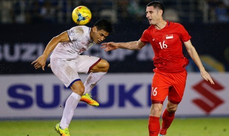 Pemain Filipina, Amani Aguinaldo (kiri) berebut bola dengan pemain Singapura, Daniel Bennett pada laga Grup A Piala AFF 2016 di stadion Philippine Sport, Sabtu (19/11). Laga berakhir imbang tanpa gol. 