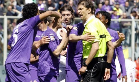 Pemain Fiorentina memprotes keputusan wasit Paolo Tagliavento (kanan) saat menghadapi AC Milan di laga Serie A Italia di Stadion Artemio Franchi, Florence, Ahad (7/4). 