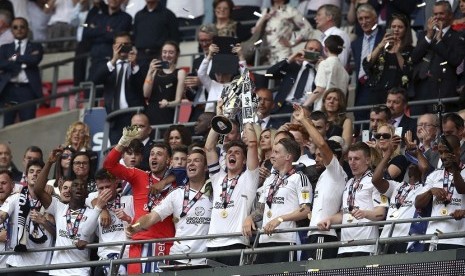 Pemain Fulham Tom Cairney (tengah) mengangkat trofi Championship, kasta kedua Liga Inggris, usai mengalahkan Aston Villa 1-0. Hasil ini membuat Fulham naik ke Liga Primer Inggris musim depan 