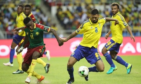 Pemain Gabon, Lloyd Palun (kanan) berebut bola dengan Edgar Salli dari Kamerun pada laga penyisihan Grup A Piala Afrika 2017, di stadion Liberville, Ahad (22/1). Gabon tersingkir setelah hanya bermain imbang tanpa gol.