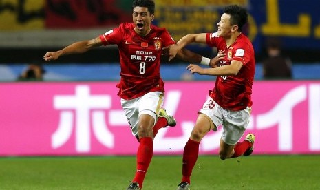 Pemain Guangzhou Evergrande, Paulinho (kiri), melakukan selebrasi usai menjebol gawang Club America asal Meksiko dalam pertandingan perempat final Piala Dunia Klub di Osaka, Jepang, Ahad (13/12). 