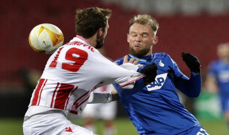 Pemain Hoffenheim, Klauss (kanan), berebut bola dengan pemain Red Star Belgrade Nemanja Milunovic dalam pertandingan Grup L Liga Europa di Belgrade, Serbia, Jumat (4/12) dini hari WIB. Laga berakhir imbang 0-0 dan Red Star menyusul Hoffenheim lolos ke babak 32 besar. 