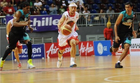 Pemain Indonesia Warriors, Mario Wuysang (tengah), menggiring bola melewati pemain Malaysia Dragons dalam sebuah pertandingan Asean Basketball League (ABL). 