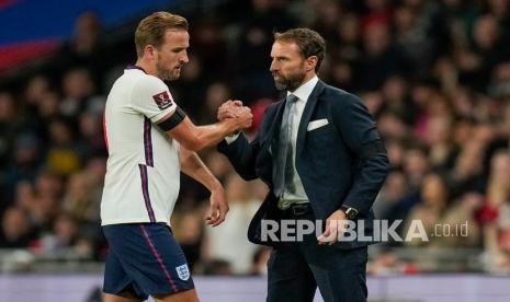  Pemain Inggris Harry Kane, kiri, berjabat tangan dengan manajer Inggris Gareth Southgate saat ia digantikan pada pertandingan sepak bola kualifikasi grup I Piala Dunia 2022 antara Inggris dan Hongaria di stadion Wembley di London, Rabu (13/10) dini hari WIB. 