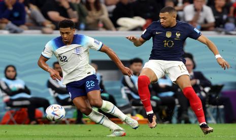 Pemain Inggris Jude Bellingham (kiri) berebut bola dengan pemain Prancis Kylian Mbappe (kanan) pada pertandingan perempat final Piala Dunia 2022 Qatar di Stadion Al Bayt, Ahad (11/12) WIB.