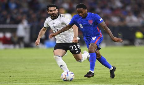 Pemain Inggris Raheem Sterling, kanan, berebut bola dengan pemain Jerman lkay Gundogan selama pertandingan sepak bola UEFA Nations League antara Jerman dan Inggris di Allianz Arena, di Munich, Jerman, Selasa, 7 Juni 2022. 