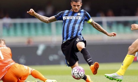 Pemain Inter Milan, Mauro Icardi (tengah), melepaskan tembakan menjebol gawang Chievo Verona dalam laga Serie A Italia di Stadion Bentegodi, Verona, Italia, Ahad (20/9). 