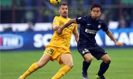 Pemain Inter Milan, Yuto Nagatomo (kanan), berebut bola dengan pemain Verona, Fabrizio Cacciatore, dalam laga Serie A Italia di Stadion Giuseppe Meazza, Milan, Sabtu (26/10). 