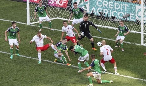 Pemain Irlandia Utara berusaha menghadang tendangan yang dilepaskan pemain Polandia, Kamil Glik (dua dari kiri), dalam pertandingan kualifikasi Grup C Piala Eropa 2016 di Allianz Riviera Stadium. 