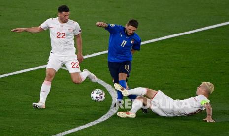 Pemain Italia Domenico Berardi  (tengah)  ditekel pemain Swiss Granit Xhaka pada pertandingan grup A kejuaraan sepak bola Euro 2020 antara Italia dan Swiss di stadion Olimpiade Roma, Kamis (17/6) dini hari WIB.