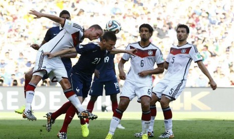 Pemain Jerman, Benedikt Hoewedes (kiri), menyapu bola saat menghadapi Prancis di laga perempat final Piala Dunia 2014 di Stadion Maracana, Rio de Janeiro, Jumat (4/7). 